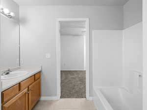 Bathroom featuring tile patterned flooring, shower / bath combination, and vanity