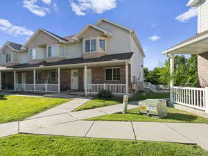 View of front of home featuring a front yard and covered porch