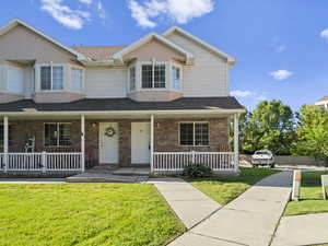 View of front of property with a front lawn and covered porch