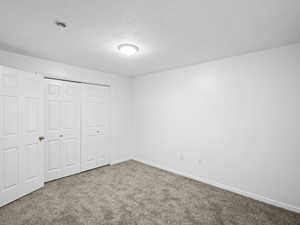 Unfurnished bedroom with carpet and a closet