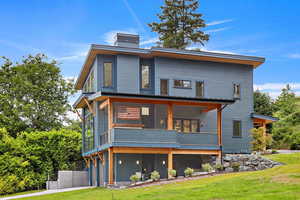 EXAMPLE Of Rear view of property with a balcony and a yard