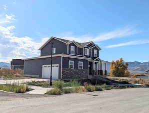 View of front of property with a garage and a mountain view