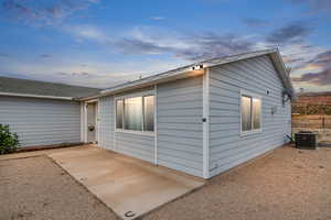 View of front of home with central AC and a patio