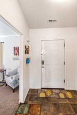 Entryway featuring dark carpet