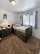 Bedroom featuring a textured ceiling and carpet flooring