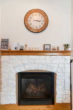 Room details with a stone fireplace and hardwood / wood-style flooring