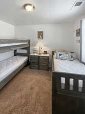 Bedroom with a textured ceiling and carpet floors