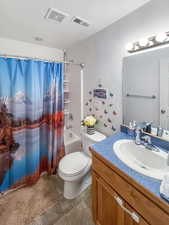 Full bathroom featuring shower / bath combo with shower curtain, vanity, toilet, and tile flooring