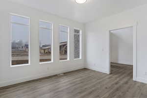 Unfurnished room with a wealth of natural light and wood-type flooring