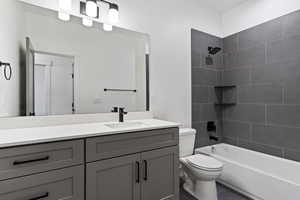 Full bathroom featuring tiled shower / bath combo, tile flooring, toilet, and vanity