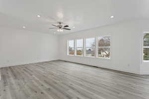 Unfurnished room with a healthy amount of sunlight, ceiling fan, and light hardwood / wood-style flooring