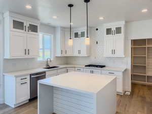 Kitchen with white cabinets, dishwasher, light wood-type flooring, and sink