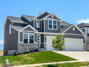 Craftsman-style house featuring a garage and a front yard