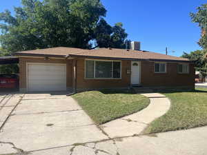 Ranch-style house with a garage and a front lawn