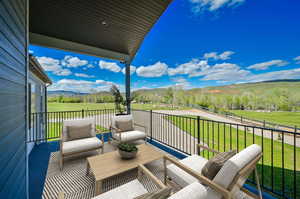 Deck with a mountain view and a lawn