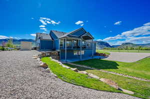 View of front of property featuring a patio area, a shed, a front yard, and a mountain view