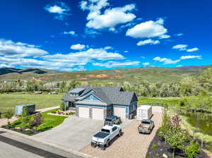 View of front of home featuring a garage, a mountain view, and a front lawn