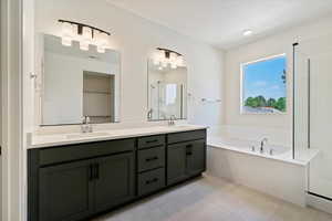 Bathroom with tile patterned floors, plus walk in shower, and dual bowl vanity