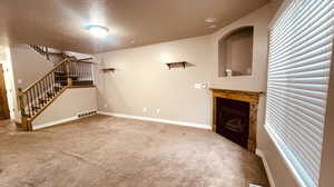 Unfurnished living room with a textured ceiling and carpet