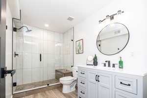 New downstairs bathroom with euro-glass enclosed shower, hardwood and large vanity