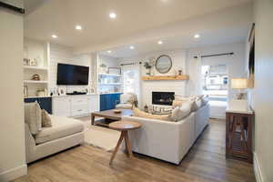 Living room featuring a large fireplace and light wood-type flooring