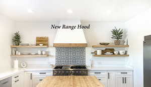 Kitchen featuring stove, white cabinets, and wood counters