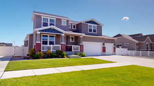 Craftsman inspired home with a porch, a garage, and a front lawn