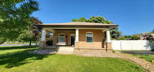 Bungalow-style home with a front yard and covered porch