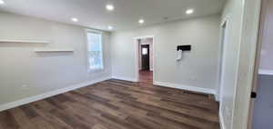 Unfurnished room with dark wood-type flooring