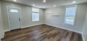 Family featuring dark hardwood / wood-style floors and beautiful windows