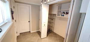 Laundry with tile flooring and crown molding and mud room