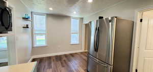 Kitchen featuring a textured ceiling, hardwood / wood-style floors, and stainless steel appliances