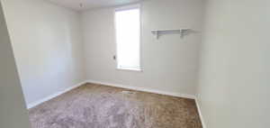 Unfurnished room featuring carpet floors and tall window