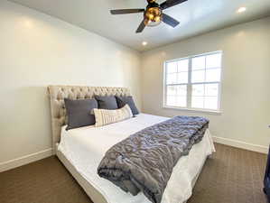 Bedroom featuring ceiling fan and dark colored carpet