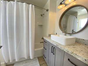 Bathroom with shower / bath combination with curtain, vanity, and tile floors