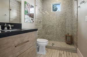 Bathroom with tile flooring, an enclosed shower, vanity, and toilet