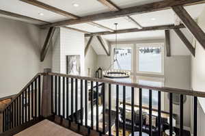 Staircase with a notable chandelier and beamed ceiling