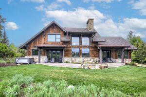 Rear view of property with a lawn and a patio area