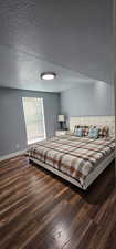 Bedroom featuring dark wood-type flooring and a textured ceiling