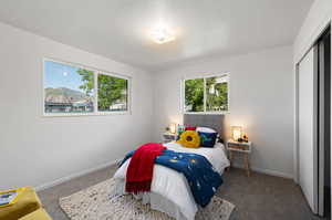 Bedroom featuring a closet and dark colored carpet