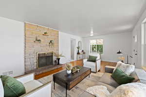 Living room with light hardwood / wood-style floors and a fireplace