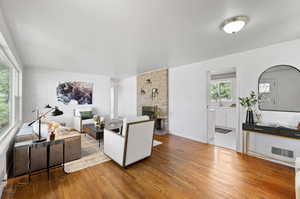 Living room with sink, hardwood / wood-style flooring, and a fireplace