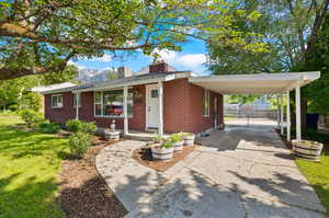 Single story home featuring a carport and a front lawn