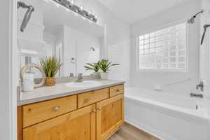 Bathroom with shower / tub combination, hardwood / wood-style flooring, and vanity