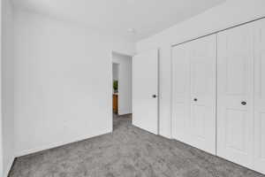 Unfurnished bedroom with a closet and carpet floors