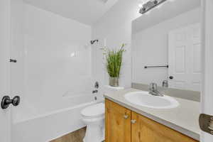 Full bathroom featuring shower / bath combination, hardwood / wood-style floors, toilet, and vanity