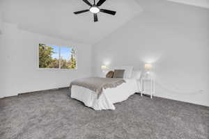 Bedroom with high vaulted ceiling, dark carpet, and ceiling fan