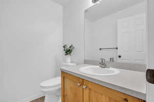 Bathroom featuring hardwood / wood-style flooring, vanity, and toilet