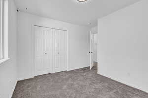 Unfurnished bedroom with carpet flooring and a closet