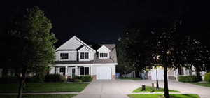 View of front of property with a garage and a yard